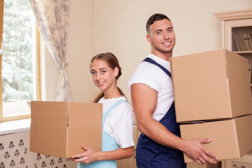 Professional movers handling furniture on a residential Tolworth street